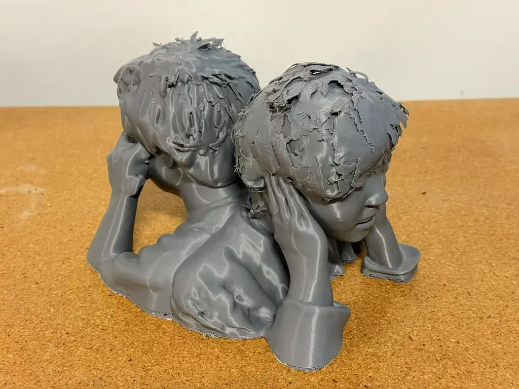 灰色3D打印双人半身像，两个头朝相反方向，从右前方拍摄。